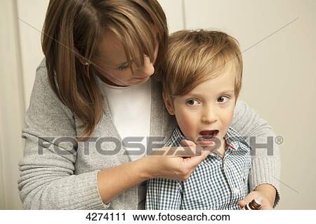 Mother giving son medicine View Large Photo Image Stock Image - Mother giving son medicine . Fotosearch