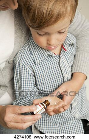 Mother giving son medicine View Large Photo Image Stock Photo - Mother giving son medicine . Fotosearch