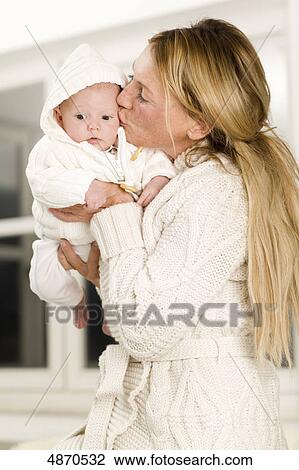 Stock Image - Mother kissing baby . Fotosearch
