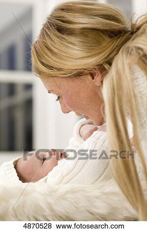 Mother looking at lying baby View Large Photo Image Stock Photo - Mother looking at lying baby . Fotosearch