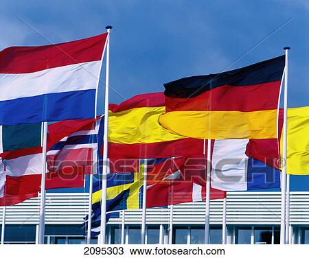Stock Image - National flags fluttering against blue sky . Fotosearch