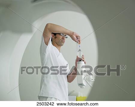 Stock Image - Nurse adjusting x-ray machine . Fotosearch
