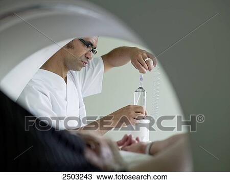 Stock Image - Nurse adjusting x-ray machine . Fotosearch