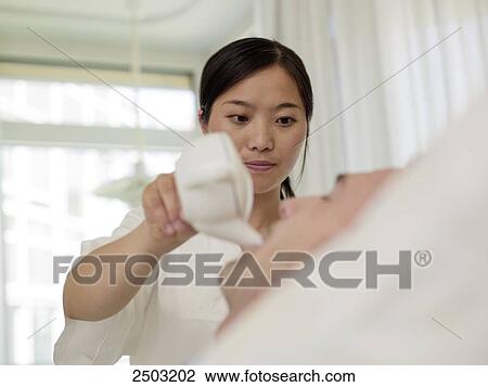 nurse giving man a drink View Large Photo Image Stock Image - nurse giving man a drink . Fotosearch