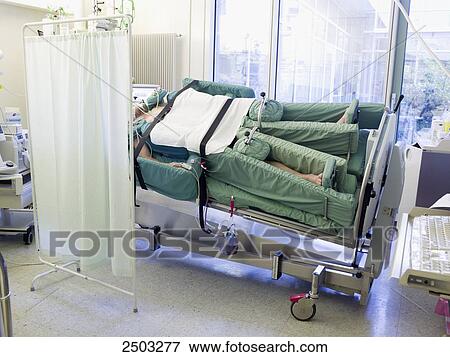 Patient lying on bed in hospital ward View Large Photo Image Stock Photo - Patient lying on bed in hospital ward . Fotosearch