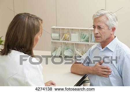 Patient with chest pains at the doctor View Large Photo Image Stock Photo - Patient with chest pains at the doctor . Fotosearch