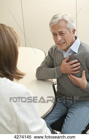 Stock Photography - Patient with chest pains at the doctor . Fotosearch