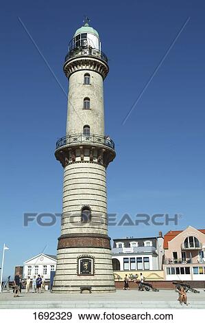 Stock Photo - People standing near lighthouse, Mecklenburg-Western Pomerania, Germany . Fotosearch
