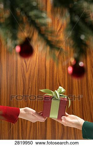 People's hands holding Christmas present View Large Photo Image Stock Image - People's hands holding Christmas present . Fotosearch