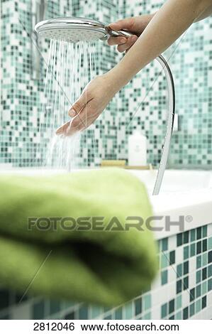 Stock Photograph - Person washing hands with shower in bathroom . Fotosearch