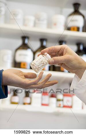 Pharmacist giving pill bottle to customer View Large Photo Image Stock Photography - Pharmacist giving pill bottle to customer . Fotosearch