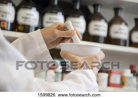 Pharmacist in pharmacy using mortar and pestle View Large Photo Image Stock Photograph - Pharmacist in pharmacy using mortar and pestle . Fotosearch