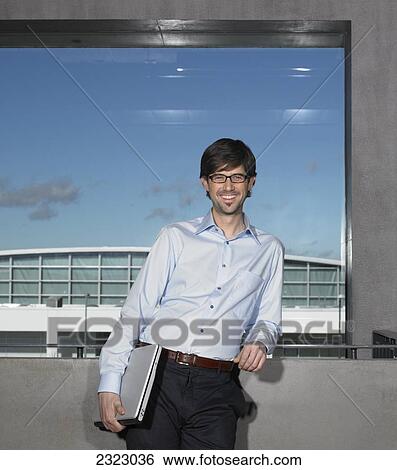 Portrait of businessman leaning against wall and smiling View Large Photo Image Stock Photograph - Portrait of businessman leaning against wall and smiling . Fotosearch