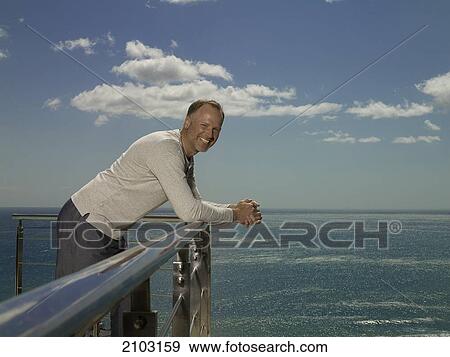 Portrait of man leaning on railing and smiling View Large Photo Image Stock Photo - Portrait of man leaning on railing and smiling . Fotosearch