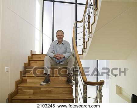 Stock Photography - Portrait of man sitting on staircase . Fotosearch