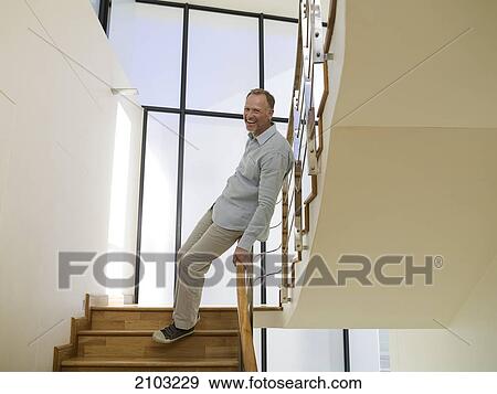 Stock Photo - Portrait of man smiling on staircase . Fotosearch