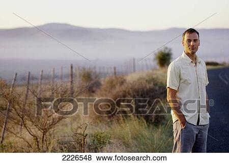 Portrait of man standing at roadside View Large Photo Image Stock Photo - Portrait of man standing at roadside . Fotosearch