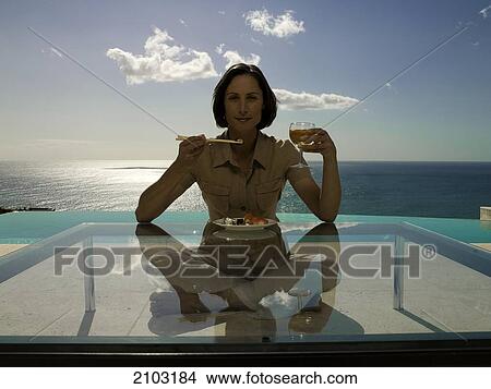 Portrait of woman having food at table View Large Photo Image Picture - Portrait of woman having food at table . Fotosearch