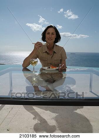 Portrait of woman having food at table View Large Photo Image Stock Photography - Portrait of woman having food at table . Fotosearch