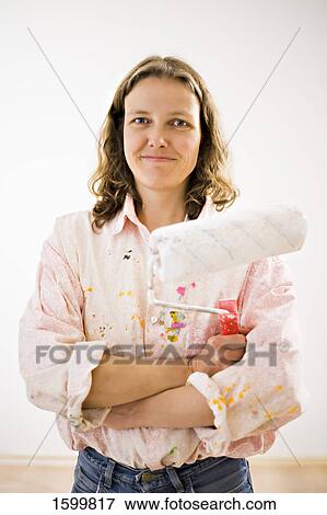 Stock Photo - Portrait of woman holding paint roller . Fotosearch