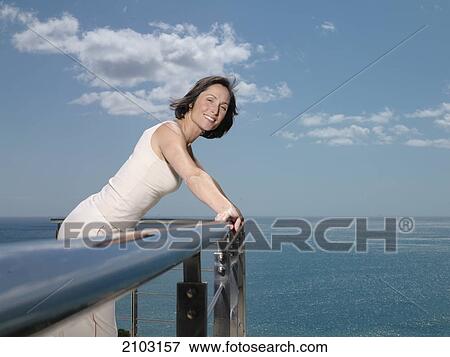 Portrait of woman leaning on railing and smiling View Large Photo Image Stock Photo - Portrait of woman leaning on railing and smiling . Fotosearch