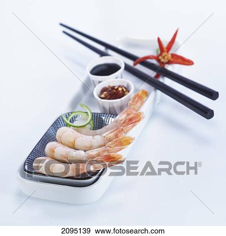 Stock Photo - Raw shrimps with chopsticks and sauce on tray . Fotosearch