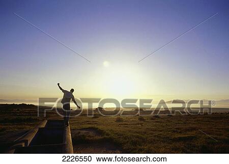 Rear view of man balancing on beach View Large Photo Image Stock Image - Rear view of man balancing on beach . Fotosearch