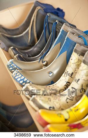 Rubber boots in a row on a shelf, close-up View Large Photo Image Stock Photo - Rubber boots in a row on a shelf, close-up . Fotosearch