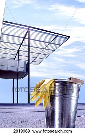Stock Photo - Rubber glove with bucket near shed . Fotosearch