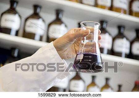Scientist holding conical flask in laboratory View Large Photo Image Stock Photo - Scientist holding conical flask in laboratory . Fotosearch