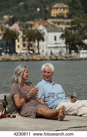 Senior couple drinking red wine by the water, Italy, Rapallo View Large Photo Image Stock Image - Senior couple drinking red wine by the water, Italy, Rapallo . Fotosearch