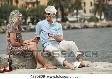 Senior couple drinking red wine by the water, Italy, Rapallo View Large Photo Image Stock Photo - Senior couple drinking red wine by the water, Italy, Rapallo . Fotosearch