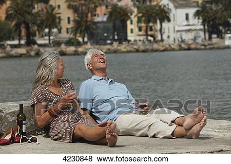 Senior couple drinking red wine by the water, Italy, Rapallo View Large Photo Image Stock Photo - Senior couple drinking red wine by the water, Italy, Rapallo . Fotosearch