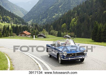 Picture - Senior couple driving in a cabriolet, North Italy, Europe, Telve, Dolomiten . Fotosearch