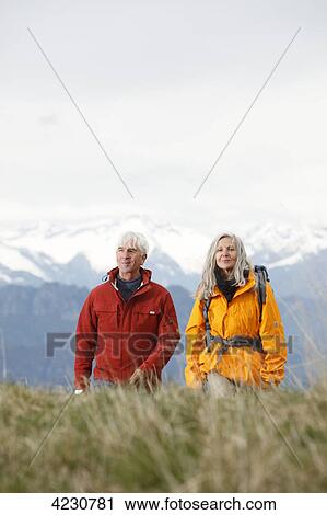 Stock Image - Senior couple hiking in mountain range, Italy, Monte Baldo . Fotosearch