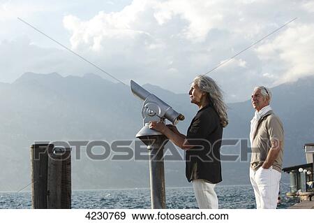 Stock Photo - Senior couple looking on water, Italy, Malcesine . Fotosearch
