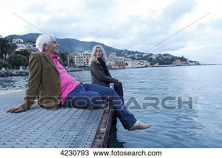 Senior couple sitting on a jetty by the water, Italy, Rapallo View Large Photo Image Stock Image - Senior couple sitting on a jetty by the water, Italy, Rapallo . Fotosearch
