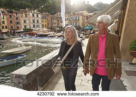 Stock Image - Senior couple walking by the water, Italy, Portofino . Fotosearch