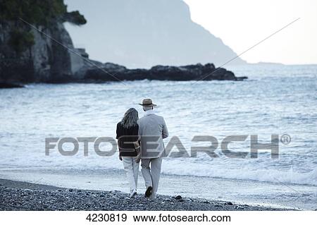 Stock Photo - Senior couple walking on beach, Italy, Sori . Fotosearch