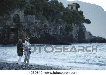 Senior couple walking on beach, Italy, Sori View Large Photo Image Stock Photo - Senior couple walking on beach, Italy, Sori . Fotosearch