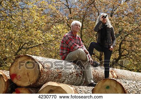 Senior couple with binoculars on tree logs, Italy, Telve View Large Photo Image Stock Image - Senior couple with binoculars on tree logs, Italy, Telve . Fotosearch