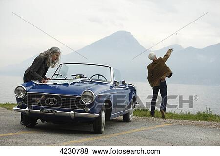 Senior couple with convertible at the ocean, Italy, Gardasee East bay View Large Photo Image Stock Photo - Senior couple with convertible at the ocean, Italy, Gardasee East bay . Fotosearch