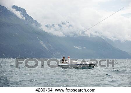 Senior couple with pedal boat in mountain scenery, Italy, Riva del Garda, Lake Garda View Large Photo Image Picture - Senior couple with pedal boat in mountain scenery, Italy, Riva del Garda, Lake Garda . Fotosearch