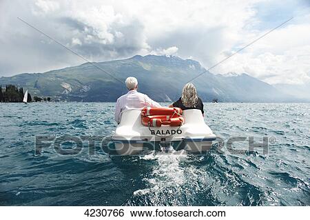 Senior couple with pedal boat in mountain scenery, Italy, Riva del Garda, Lake Garda View Large Photo Image Stock Photograph - Senior couple with pedal boat in mountain scenery, Italy, Riva del Garda, Lake Garda . Fotosearch