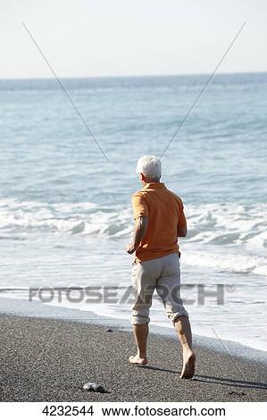 Picture - Senior jogging on beach, Italy, Sori . Fotosearch
