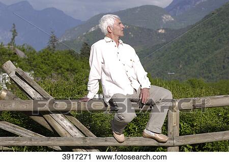 Senior man sitting on a wooden fence, North Italy, Europe, Rapallo, Dolomites View Large Photo Image Stock Image - Senior man sitting on a wooden fence, North Italy, Europe, Rapallo, Dolomites . Fotosearch