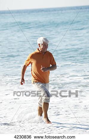 Senior wading in ocean, Italy, Sori View Large Photo Image Stock Photograph - Senior wading in ocean, Italy, Sori . Fotosearch