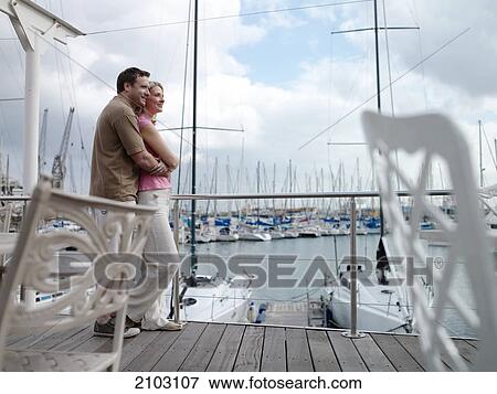 Side profile of couple romancing at harbor View Large Photo Image Stock Photo - Side profile of couple romancing at harbor . Fotosearch