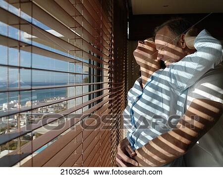 Side profile of couple romancing near window View Large Photo Image Picture - Side profile of couple romancing near window . Fotosearch