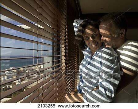 Side profile of couple romancing near window View Large Photo Image Stock Photography - Side profile of couple romancing near window . Fotosearch